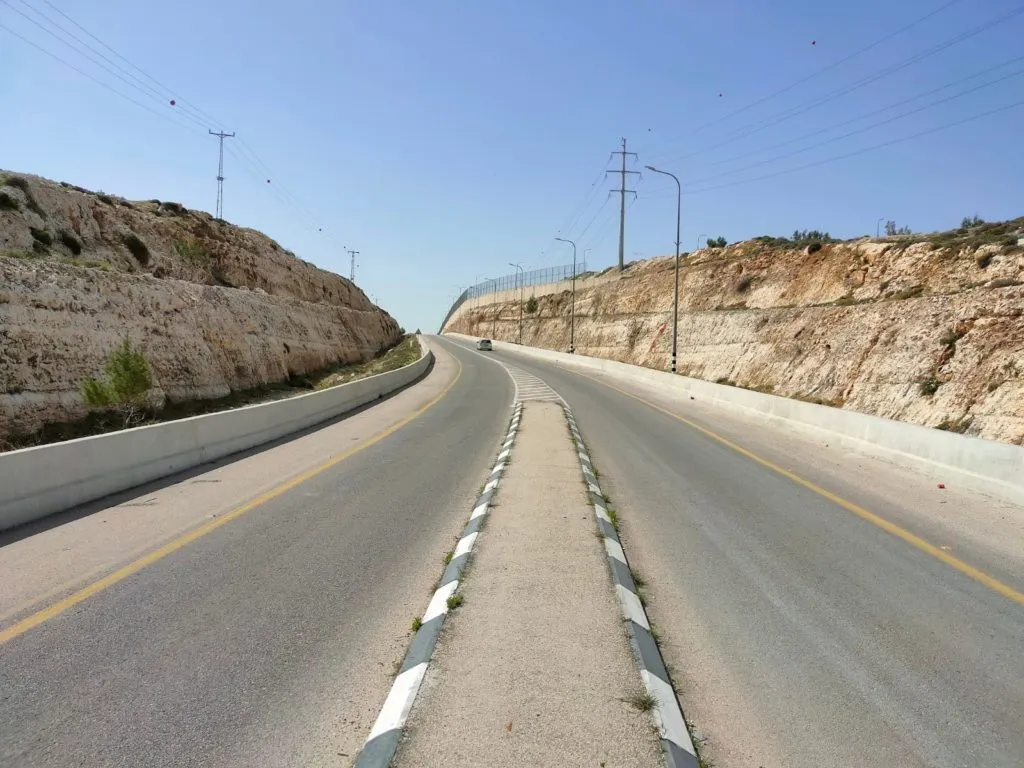 כביש הטבעת המזרחי ריק מתנועה, עובר בין מצוקי סלע חצובים ועמודי חשמל